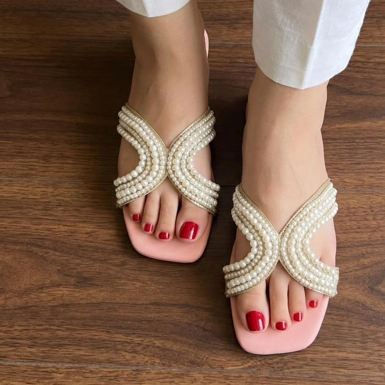 Pearl sandals worn on a wooden floor