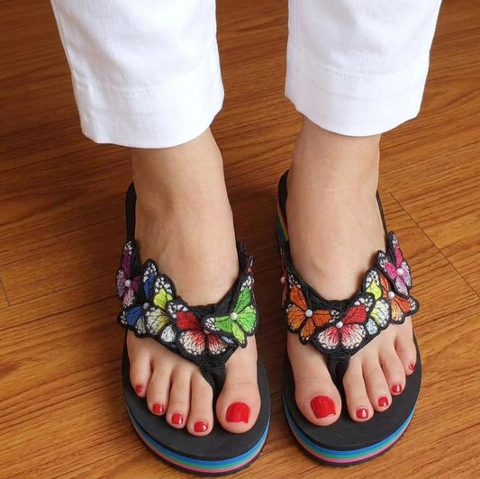 Black high-heeled sandals worn outdoors on a sunny day.