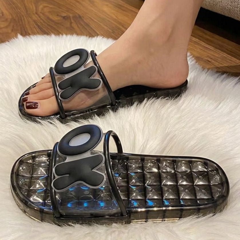 Black sandals with transparent soles on a white rug