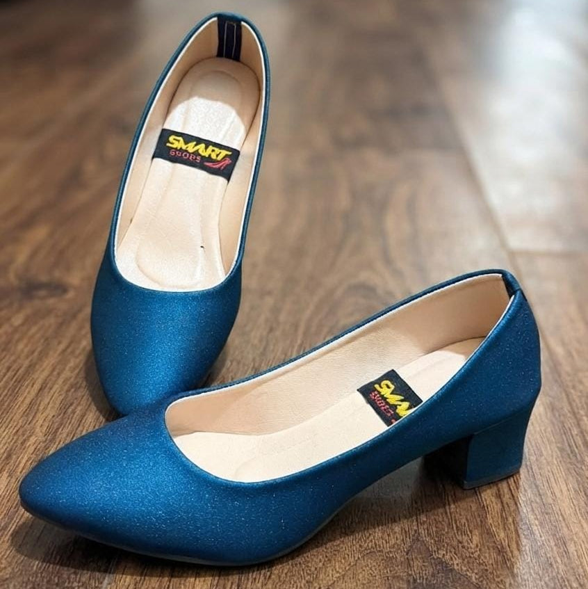 A pair of blue pointed-toe pumps with block heels, displayed on a dark wood floor. The shoes feature a satin-like finish and a visible 'SMART SHOES' brand label inside the heel cup.